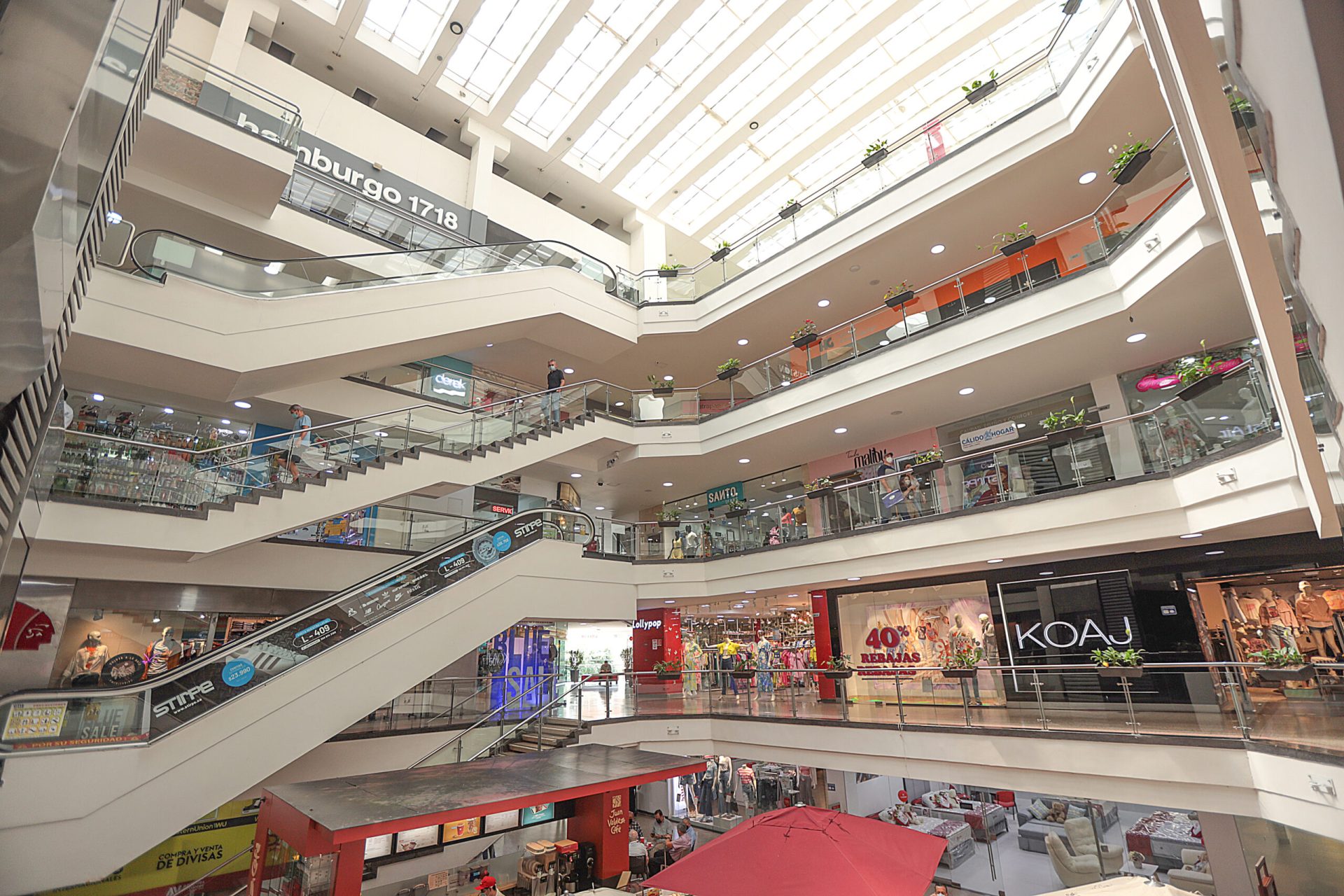 Interior del centro comercial: plazoleta central y escaleras a los pisos superiores